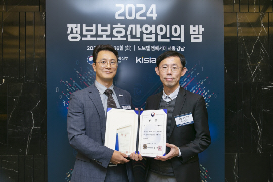 이정하(왼쪽) 토스뱅크 정보보호최고책임자와 최승현 정보보안팀 리더가 지난 26일 오후 제 23회 정보보호대상 시상식에서 대상을 수상한 후 기념 촬영을 하고 있다. [토스뱅크 제공]